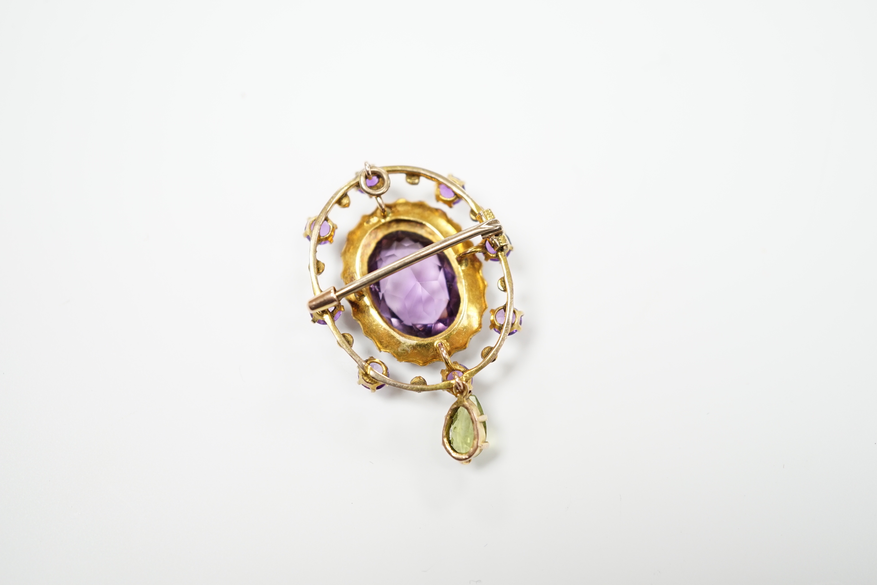An early 20th century yellow metal, amethyst, peridot and seed pearl cluster set drop pendant brooch, 35mm, gross weight 4.9 grams.